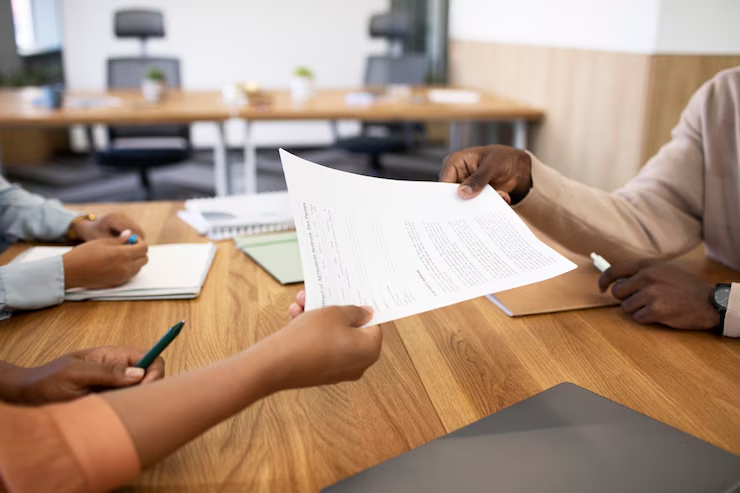 A person handing a document to another person