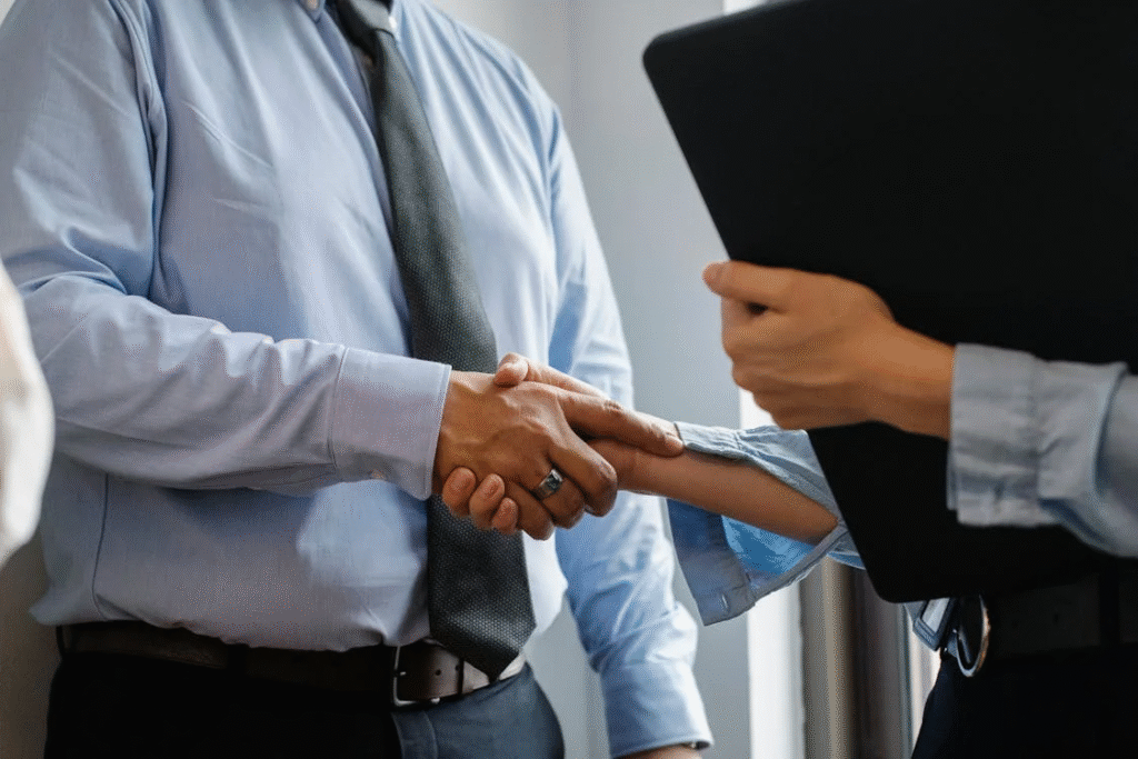 A man and a woman shaking hands in an office setting.