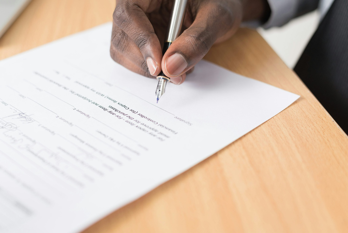 A man signing a document with a pen