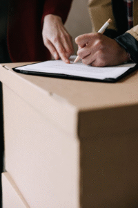 A person writing notes with a pen on white paper.