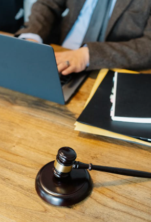 A wooden gavel resting on a polished wooden surface.