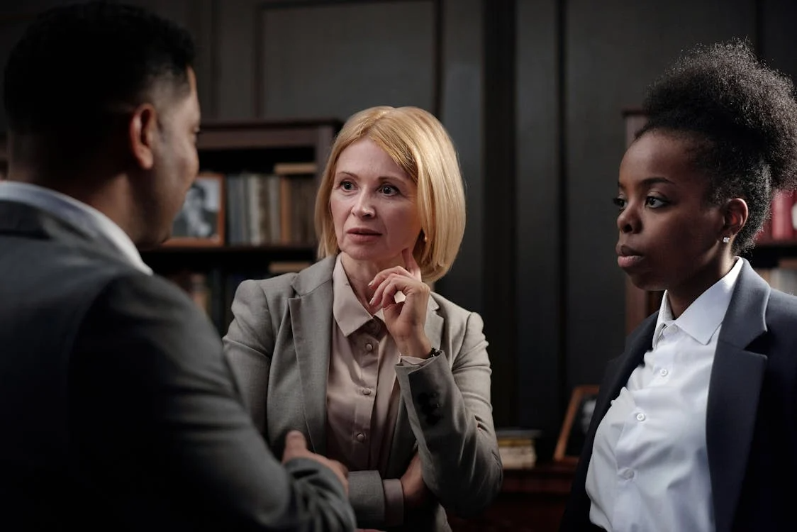 Business professionals discussing paperwork at a table.