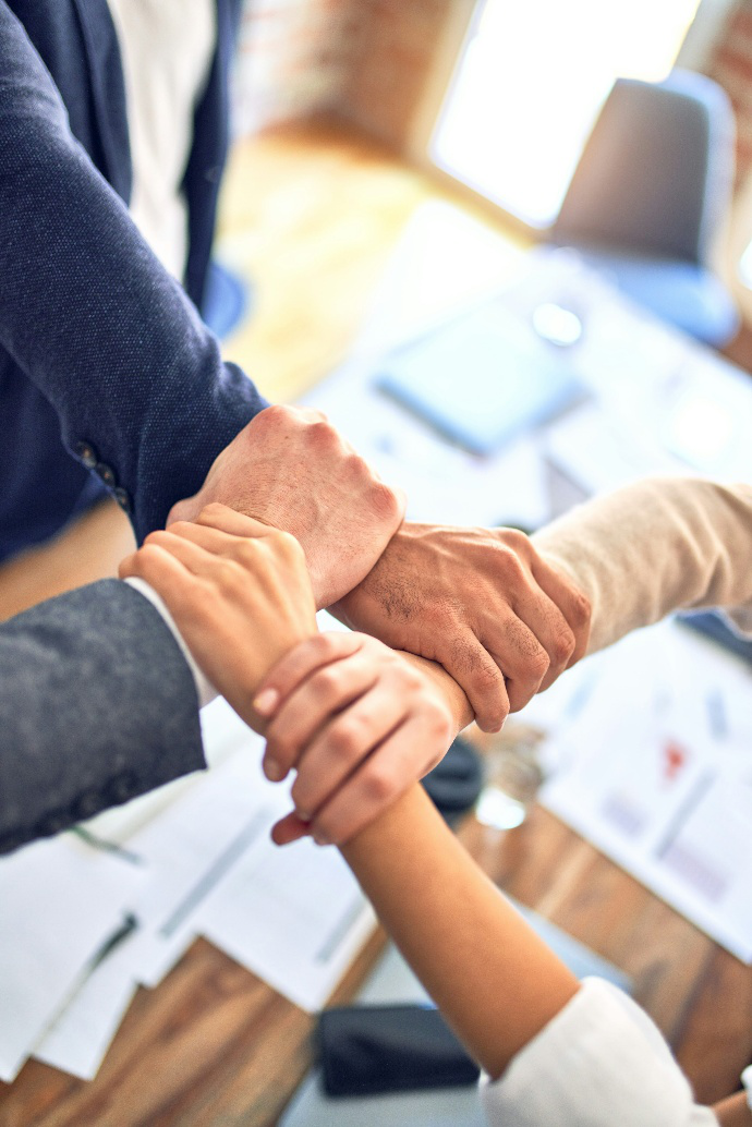 Four people connecting their hands