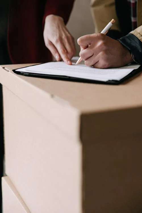 Person writing notes on white paper during a planning session.