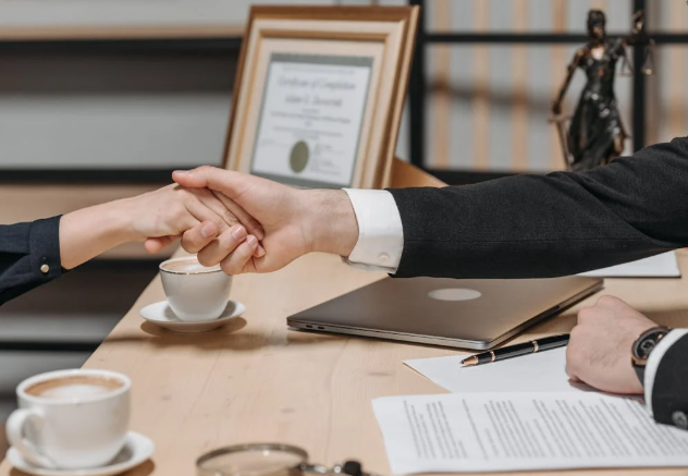 Two businesspeople shaking hands to finalize a contract agreement.
