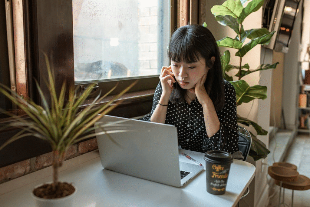 Woman researching on laptop at a business meeting table.