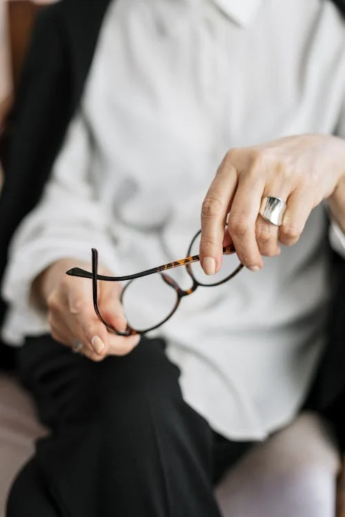 person-holding-brown-framed-eyeglasses