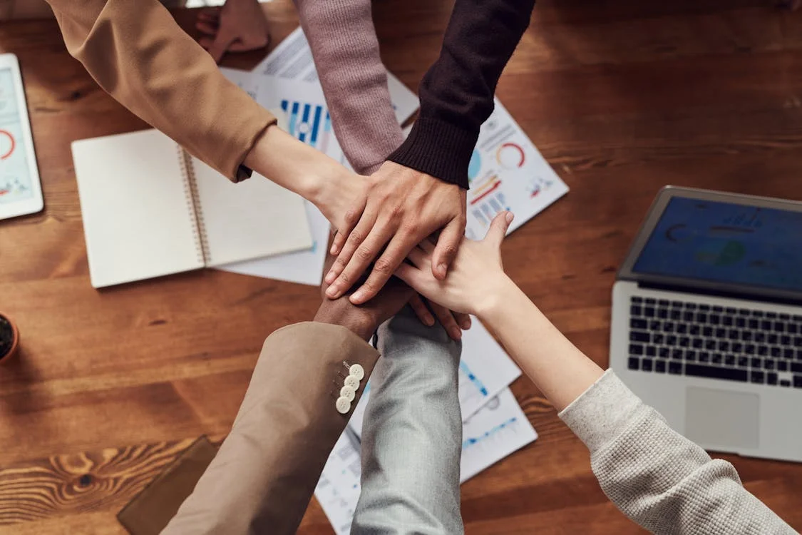 People gathered around a wooden table in a business meeting.