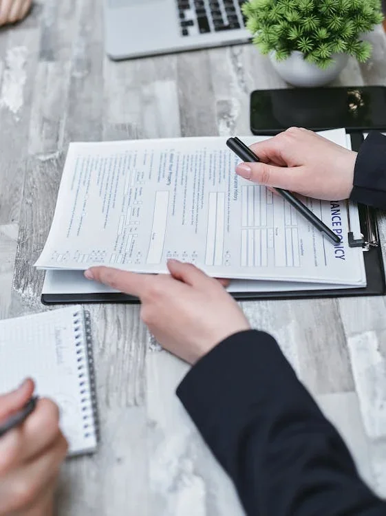 Person reviewing a printed document at a desk.