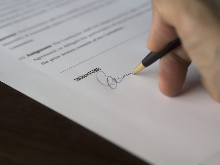 A person signing a contract.