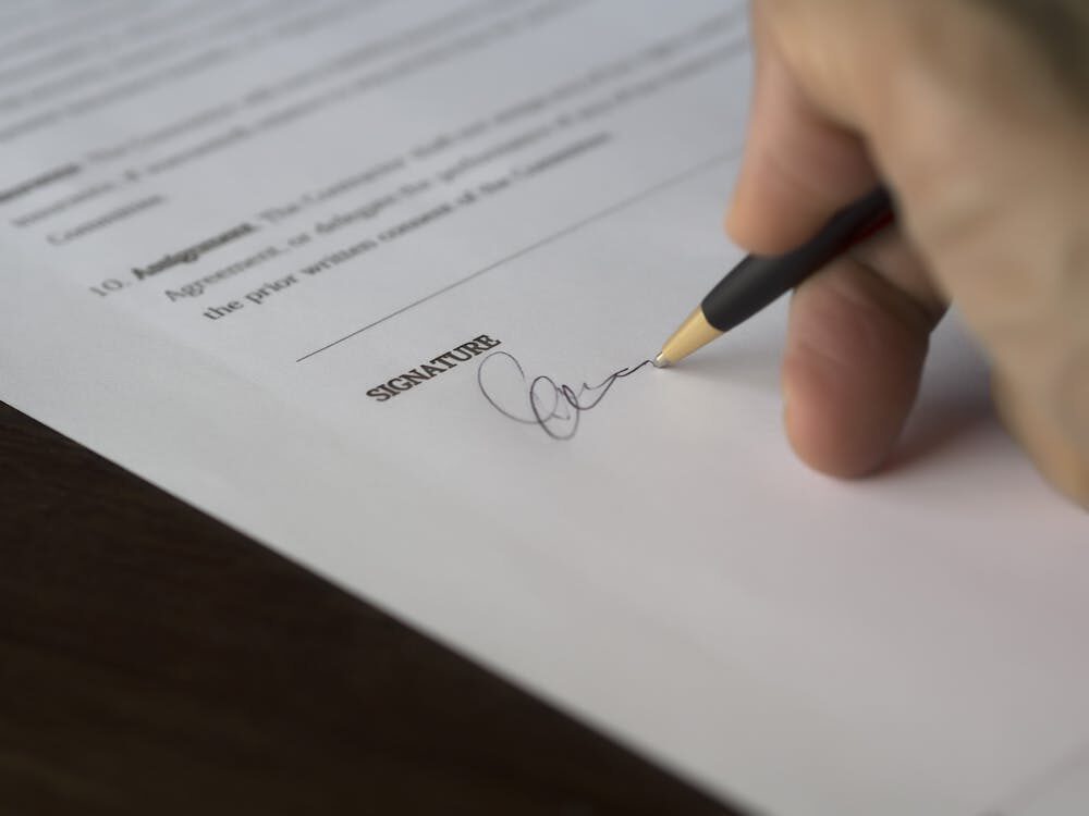 A person signing a contract.