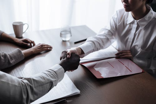 Two people shaking hands over a table