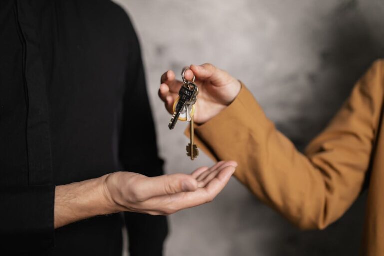 A person handing over keys to another person