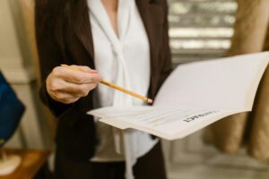 A person holding a file and a pencil