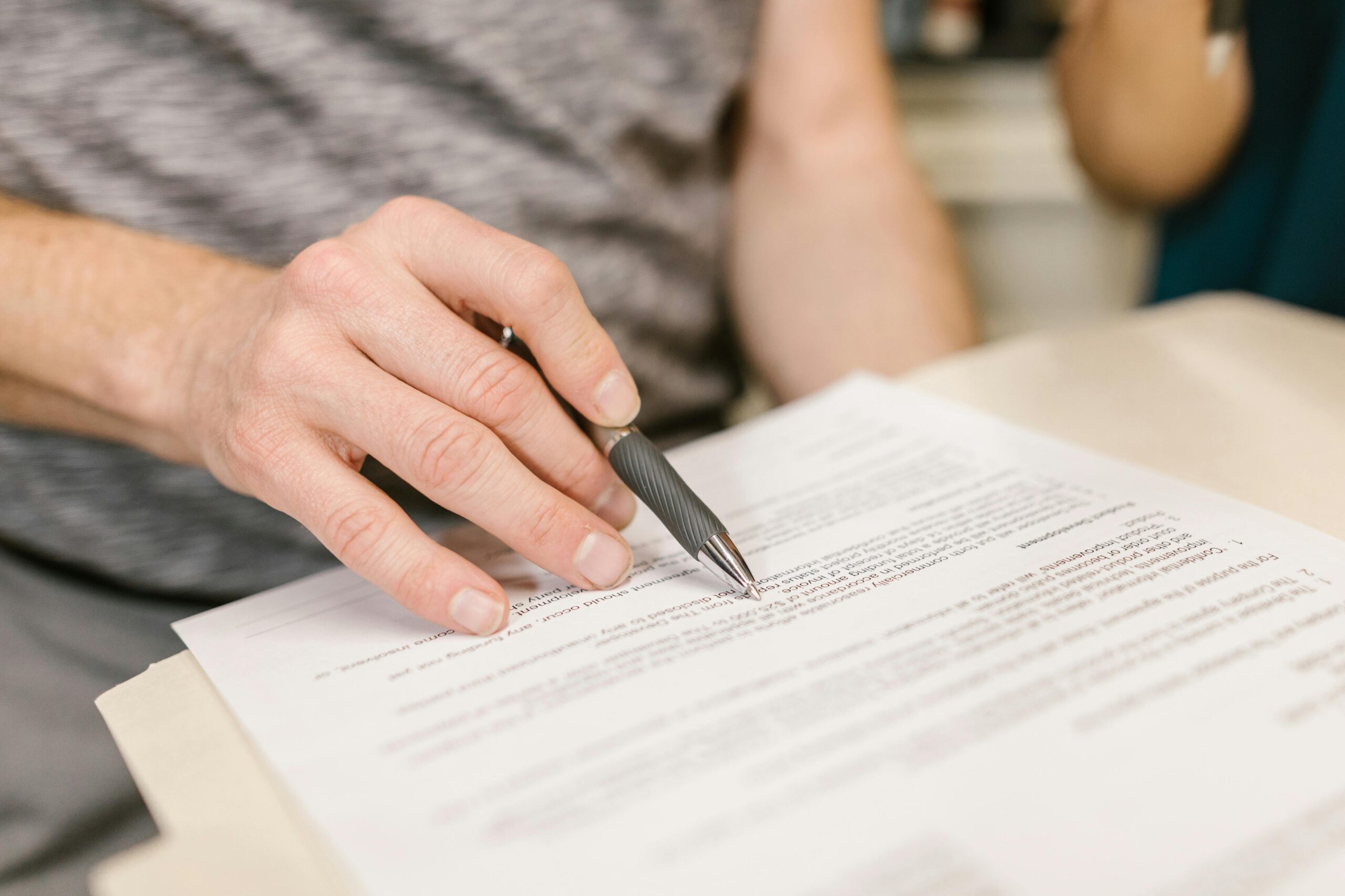 A person holding a pen to a paper