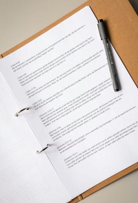 This image shows contract documents in a brown file and a black pen.