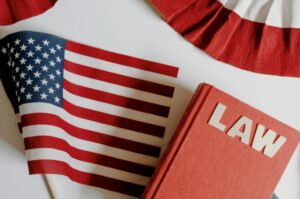 This photo shows a law book next to a USA flag.