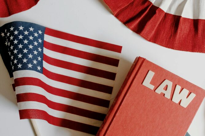 This photo shows a law book next to a USA flag.