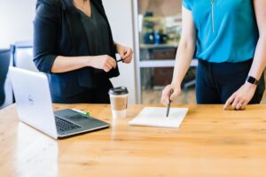 Two people checking a contract placed on a table