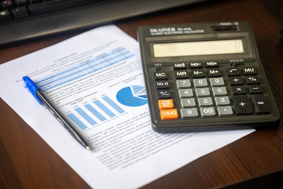 A calculator and papers on a desk