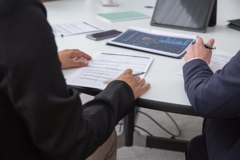 Two people reviewing papers on a desk
