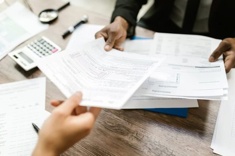 A person passing papers to another person