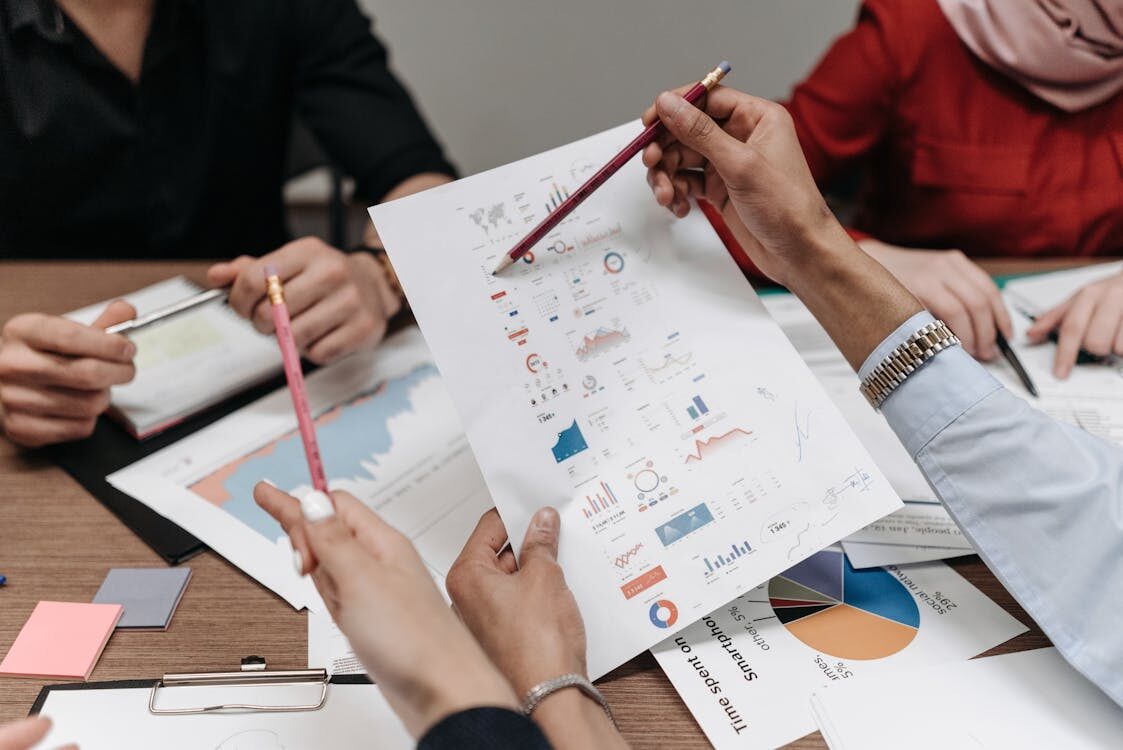 People reviewing papers with graphs on them