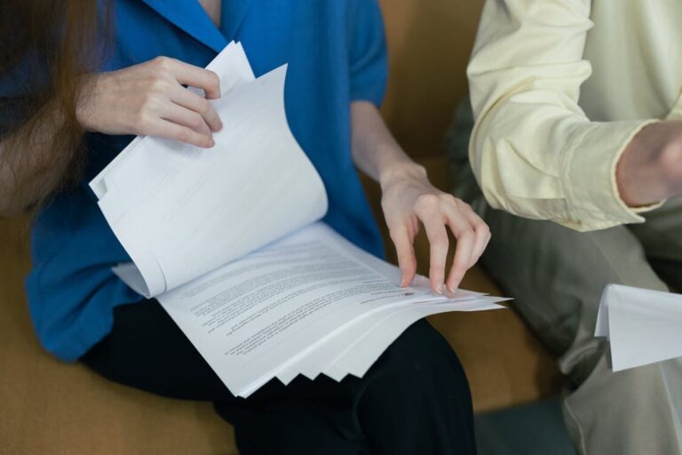 A person reviewing documents placed on their lap