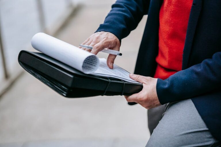 A person reviewing papers placed in a file