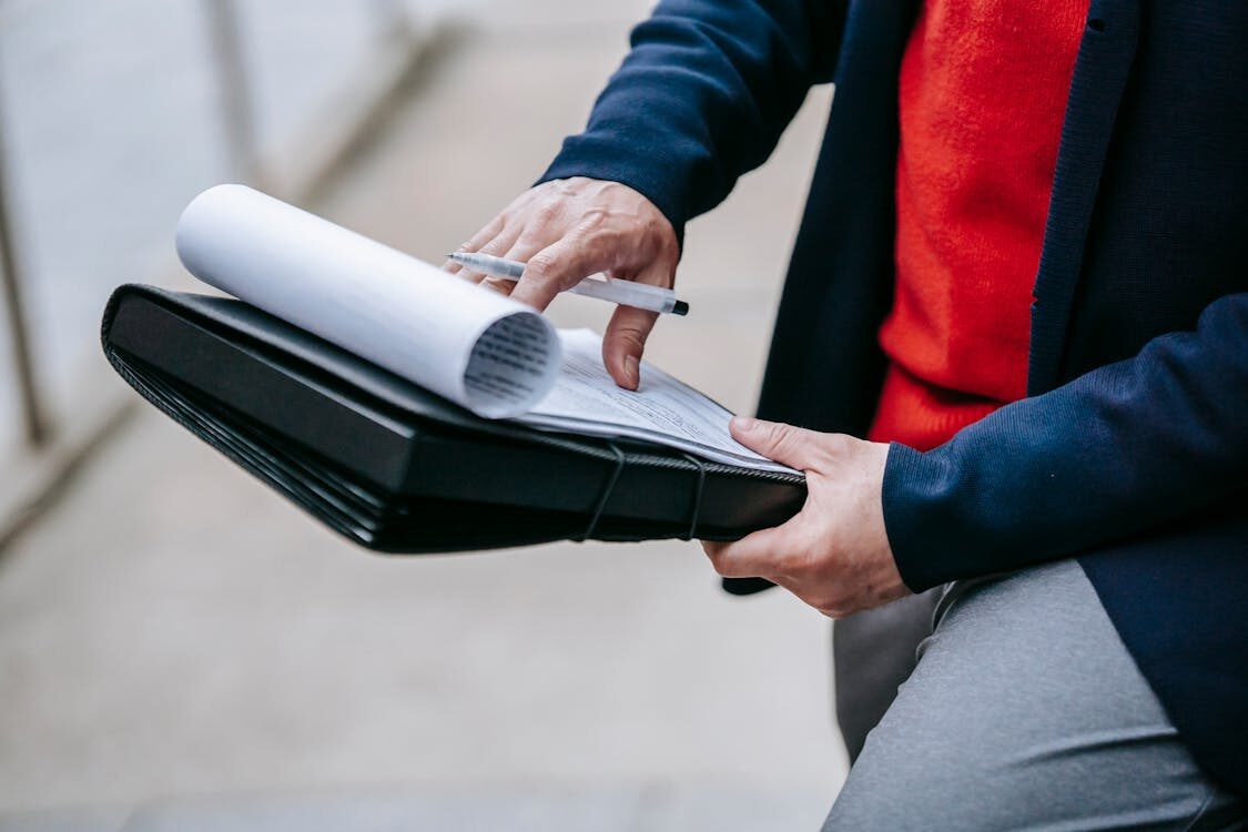 A person reviewing papers placed in a file