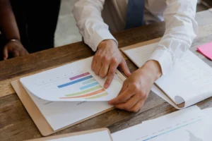A person pointing to graphs on a paper