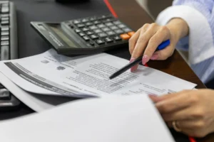 A person reviewing papers with a pen