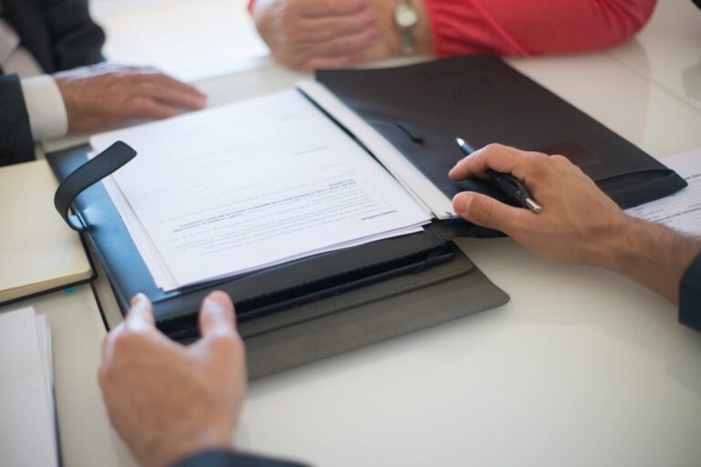 Several people reviewing a contract in a file
