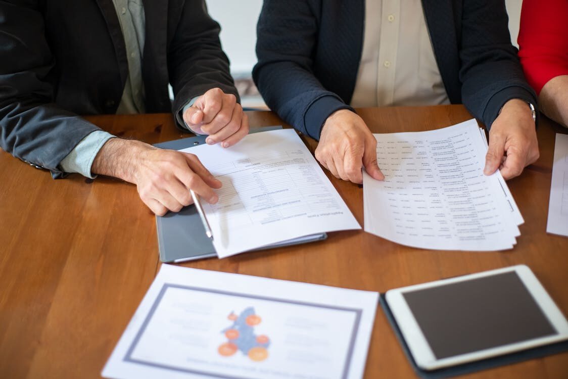 Two people reviewing papers on a table