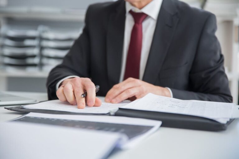 A person reviewing documents in a file