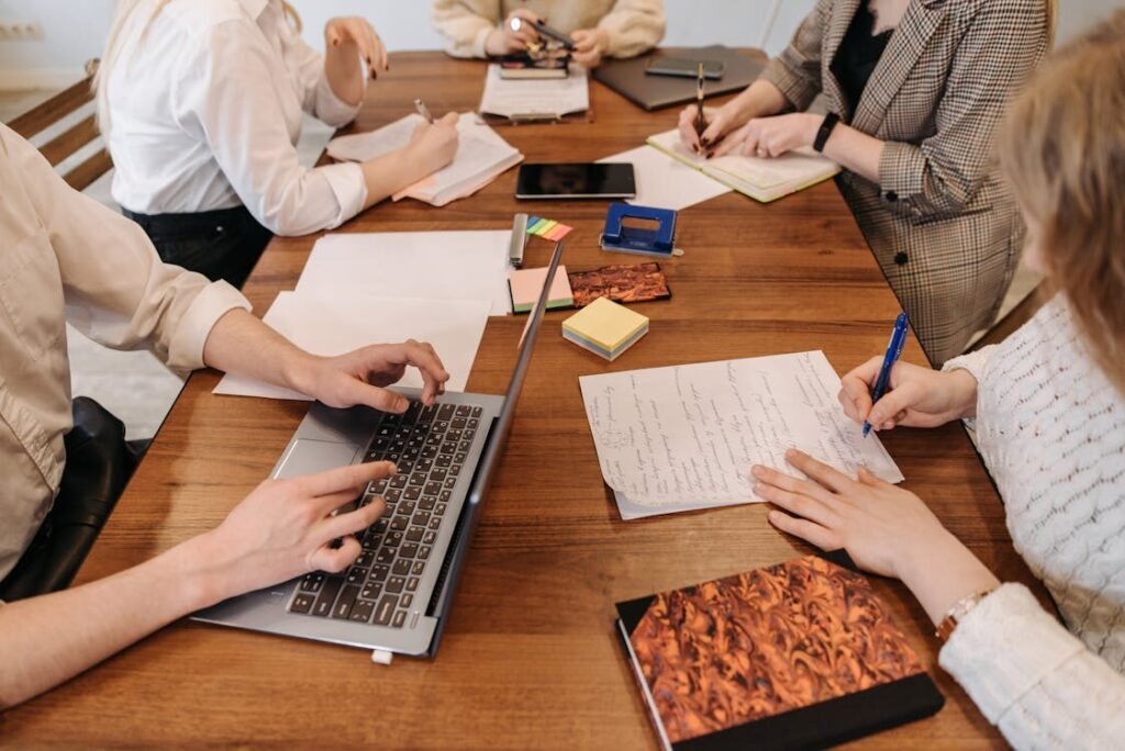A group of people with papers and laptops