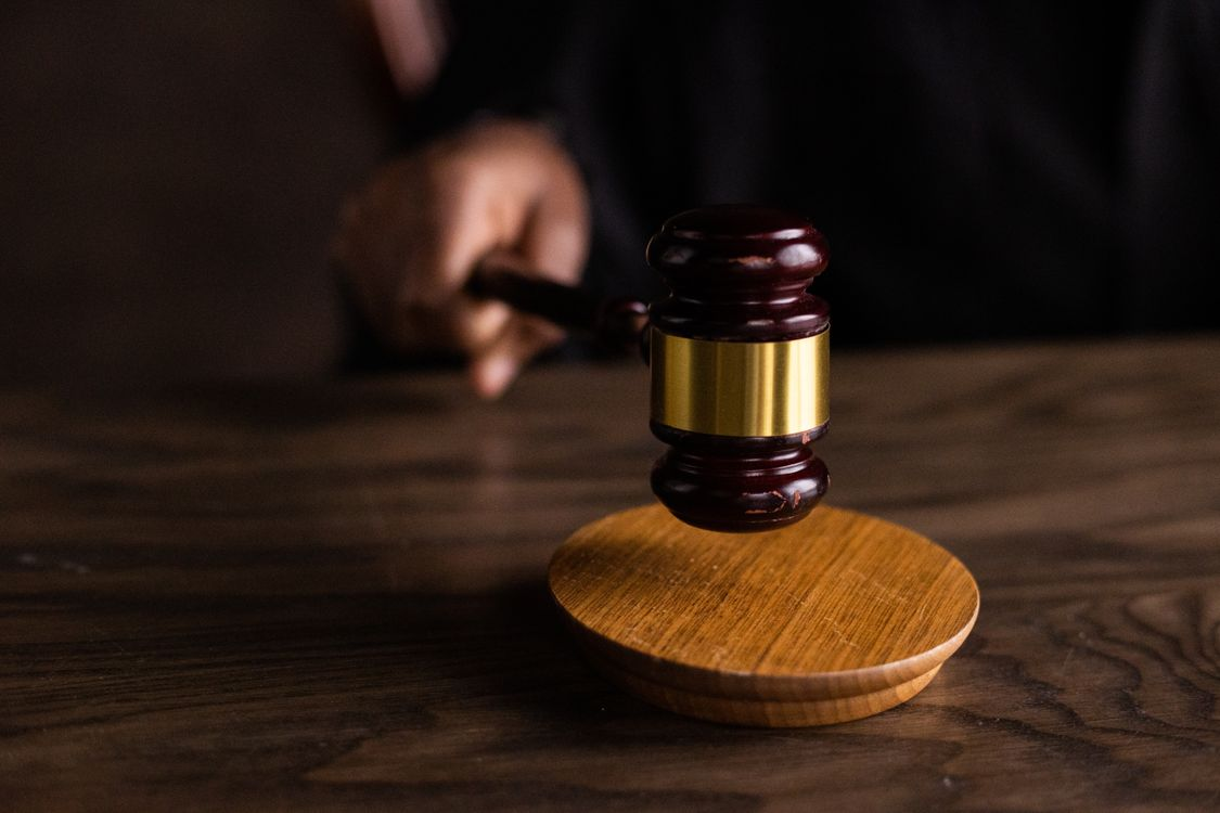 A hand holding a gavel