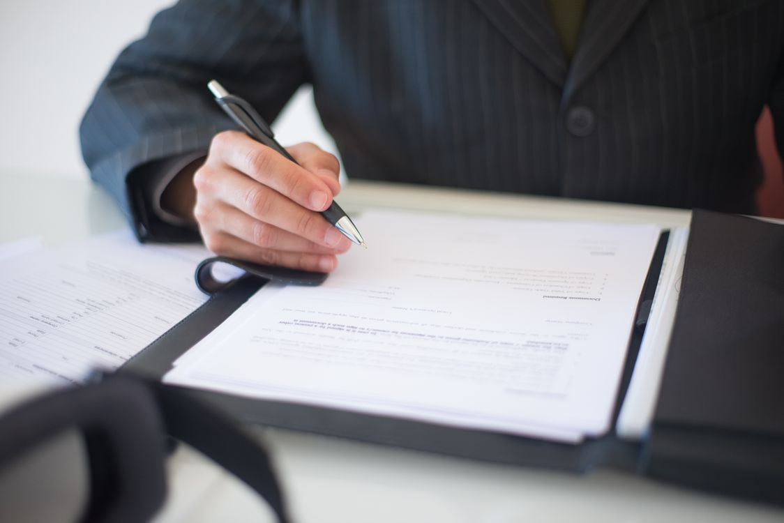 A person signing a paper in a file