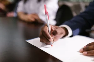 Business professional reviewing documents and marking a contract with a pen at a desk