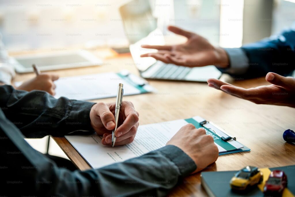 Three people with documents and devices during a meeting