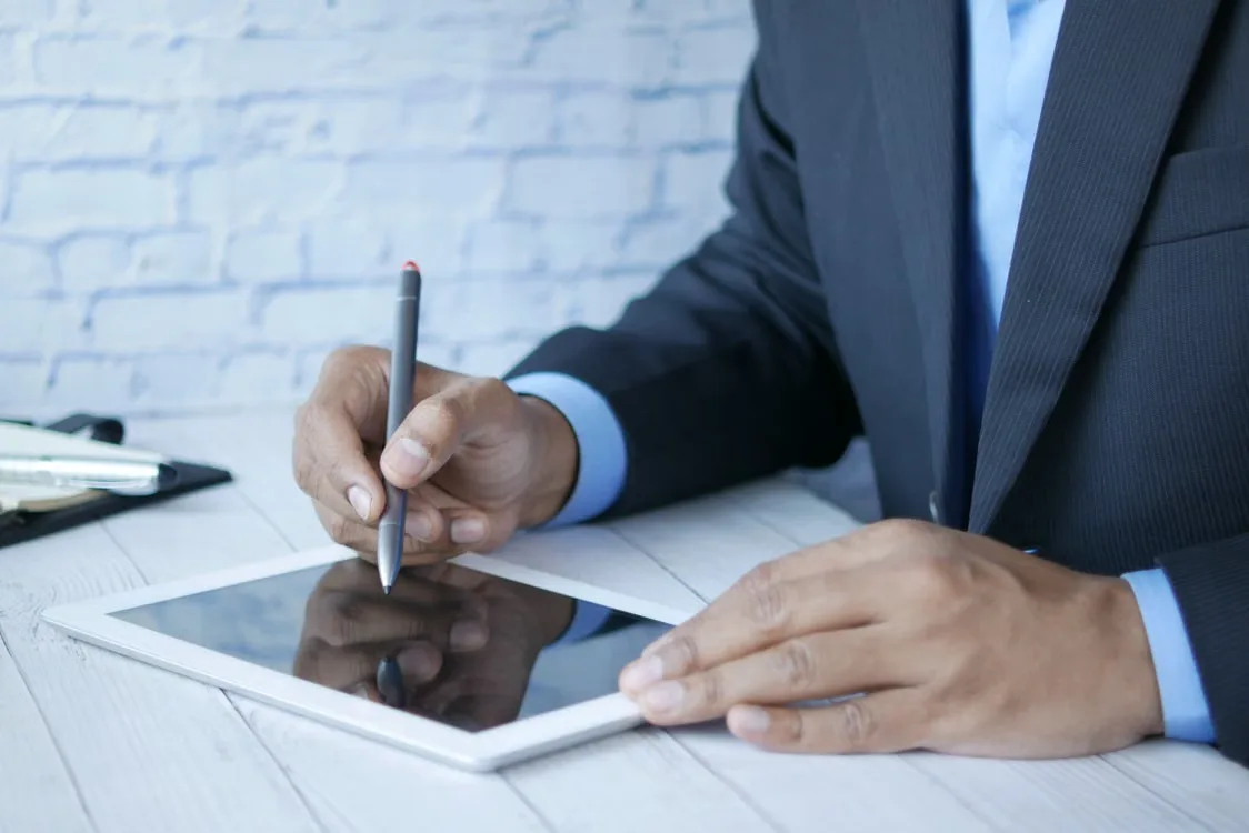 A business professional reviewing an electronic document and applying a digital signature on a tablet.