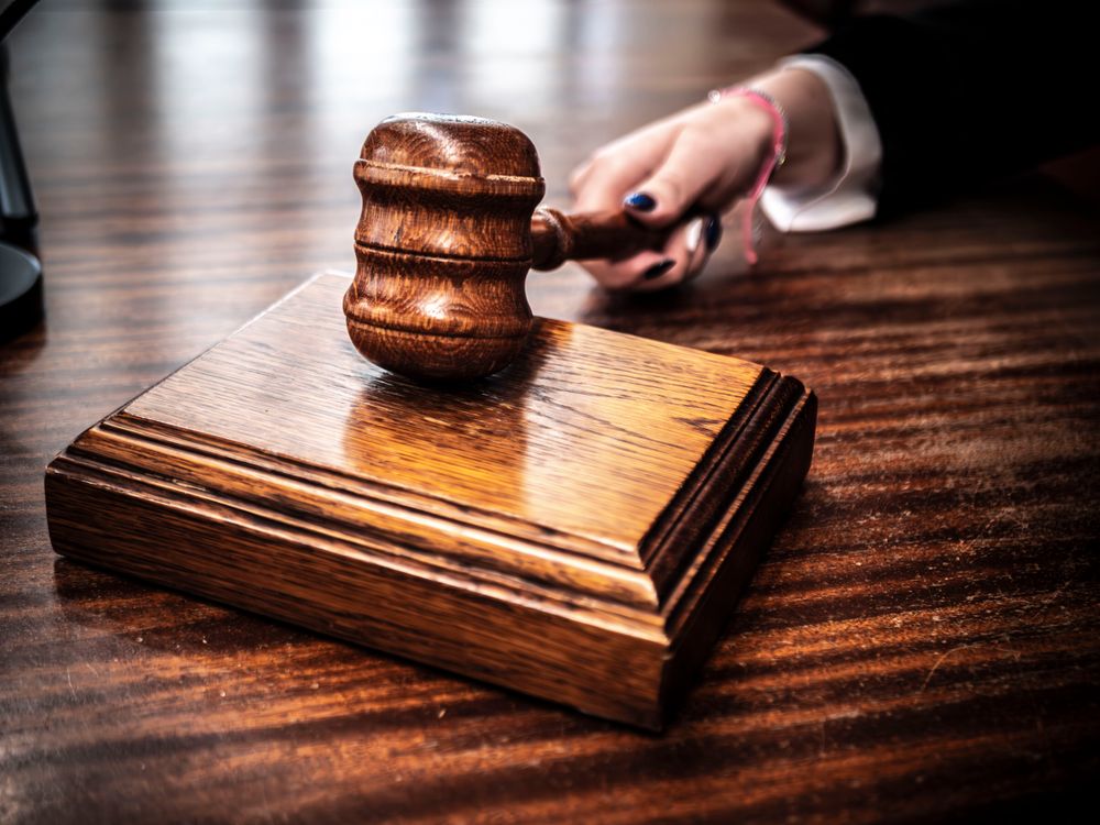 A person holding a wooden gavel