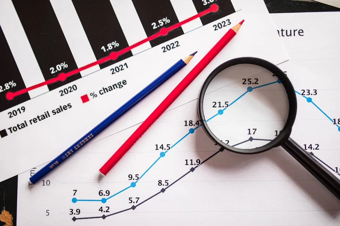Colored pencils and a magnifying glass over performance graphs