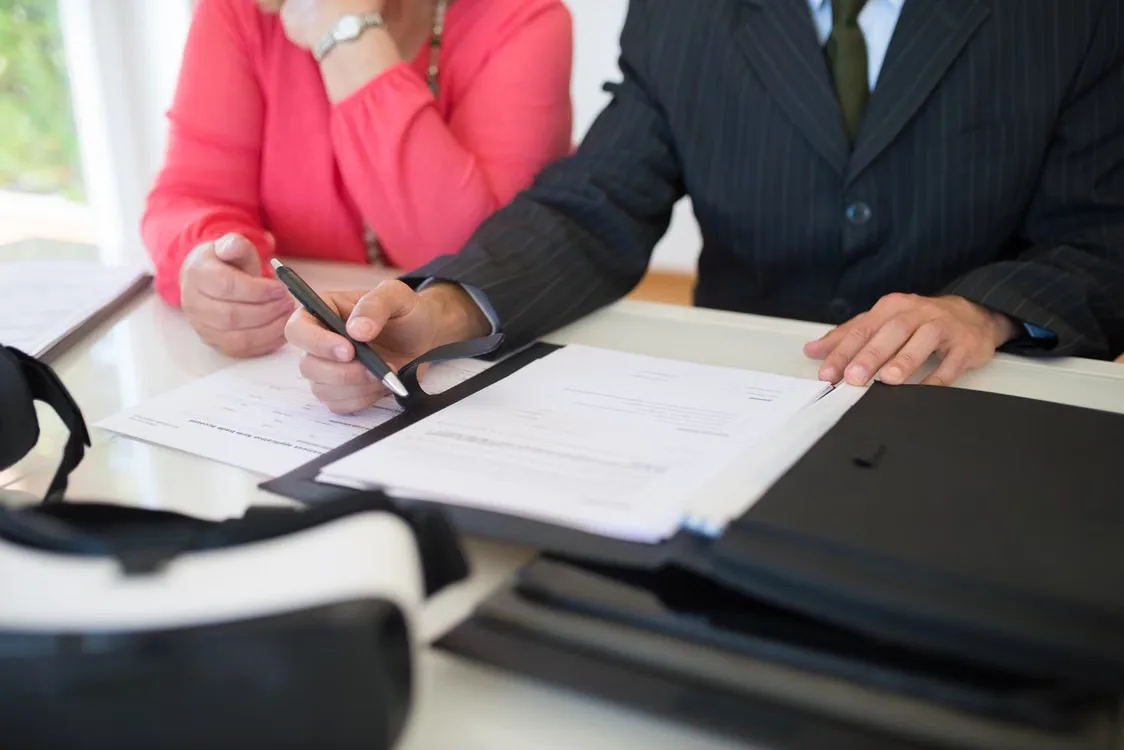 Two people reviewing papers in a file