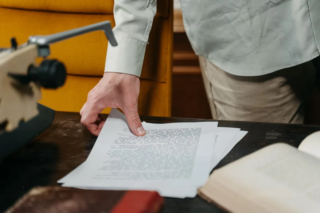 A person picking up papers from the table
