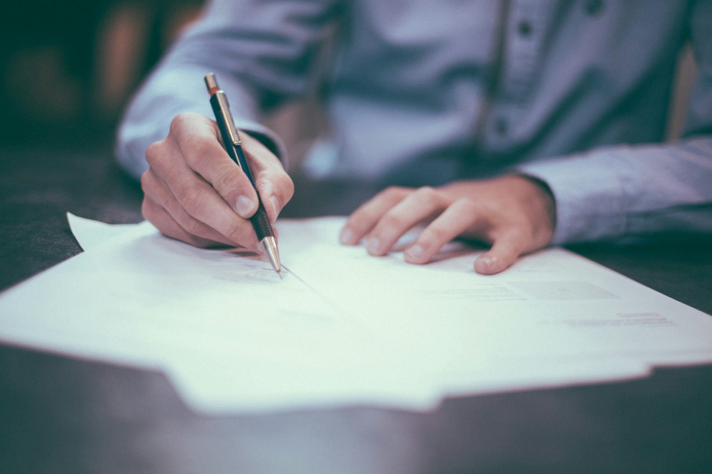 A man is writing on paper