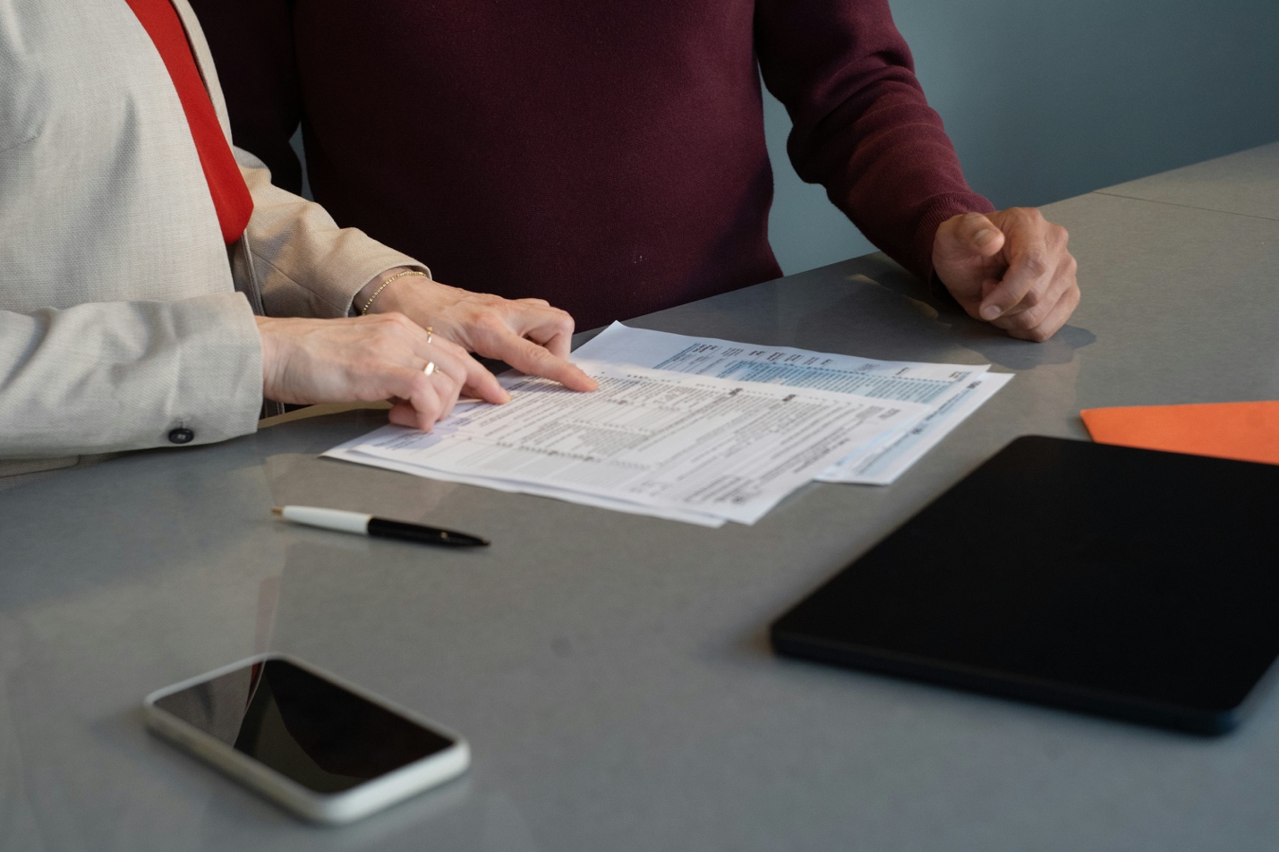 Two people reviewing documents during a meeting